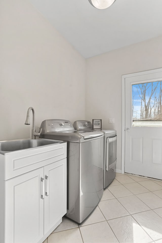 clothes washing area featuring cabinet space, light tile patterned floors, separate washer and dryer, and a sink