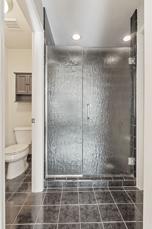 bathroom featuring tile patterned floors, visible vents, a shower stall, and toilet