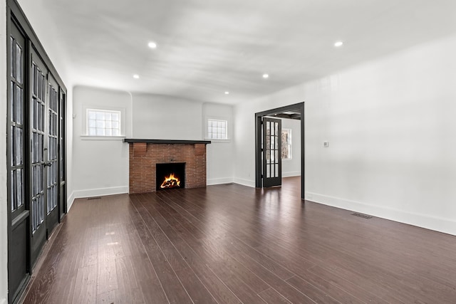 unfurnished living room featuring dark hardwood / wood-style flooring and french doors