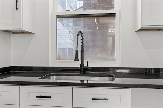 kitchen featuring white cabinetry and sink