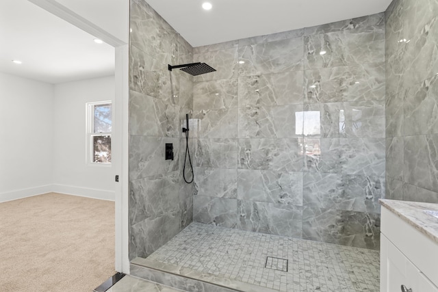 bathroom with a tile shower and vanity