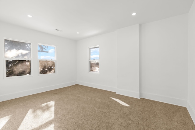 unfurnished room with a wealth of natural light and carpet