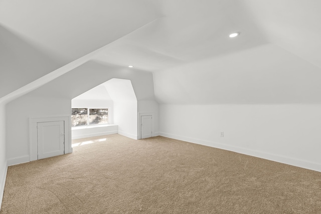 additional living space featuring lofted ceiling and carpet floors