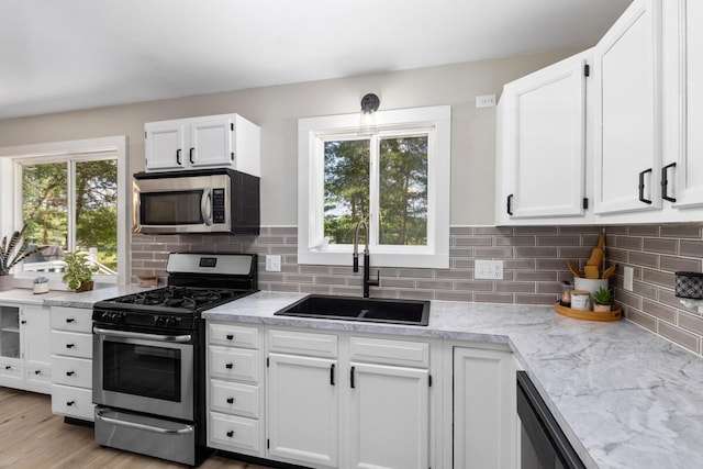 kitchen featuring backsplash, appliances with stainless steel finishes, sink, and white cabinets