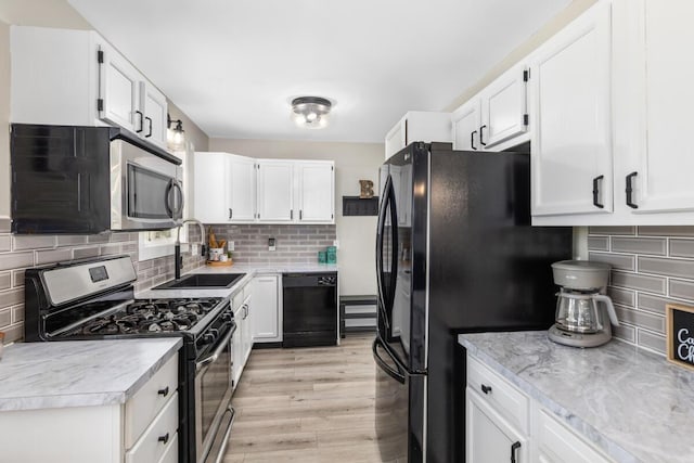 kitchen featuring sink, decorative backsplash, black appliances, and white cabinets