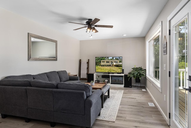 living room featuring light hardwood / wood-style flooring and ceiling fan