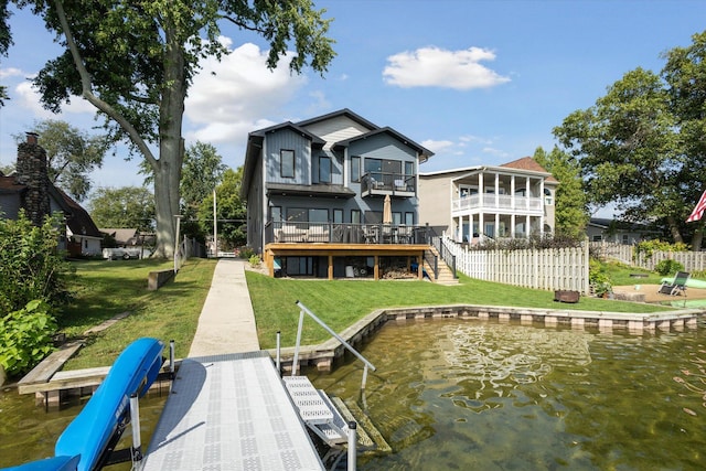 back of property with a yard, a balcony, and a water view