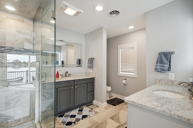 bathroom with vanity, a shower with door, and toilet