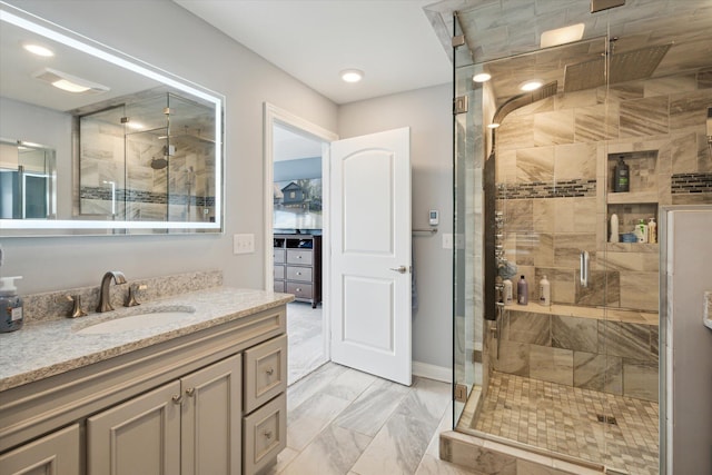 bathroom with a shower with door and vanity