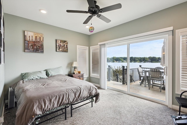 bedroom with a water view, ceiling fan, carpet, and access to outside