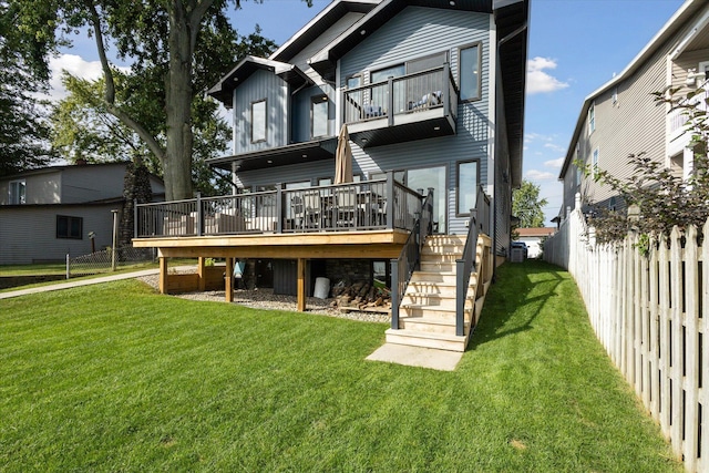 rear view of property with a yard and a deck