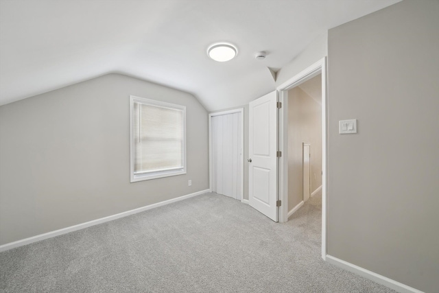 bonus room featuring lofted ceiling and light colored carpet