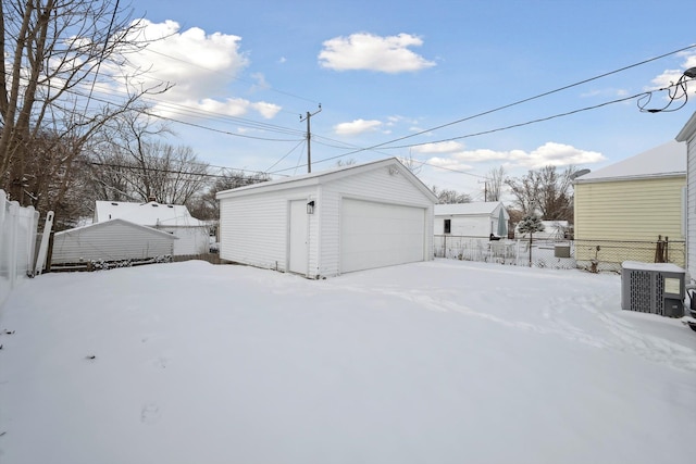 snow covered garage featuring cooling unit