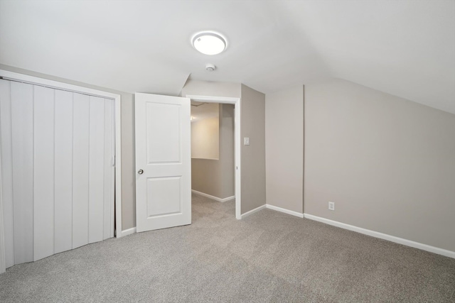 additional living space featuring lofted ceiling and light colored carpet