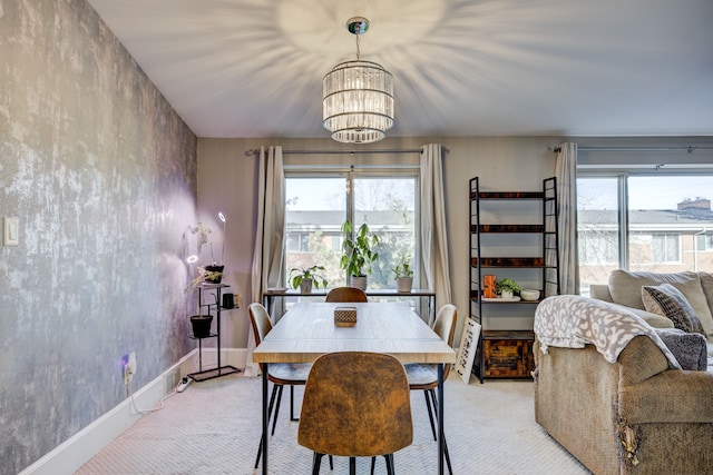 dining area with a healthy amount of sunlight, an inviting chandelier, light carpet, and baseboards