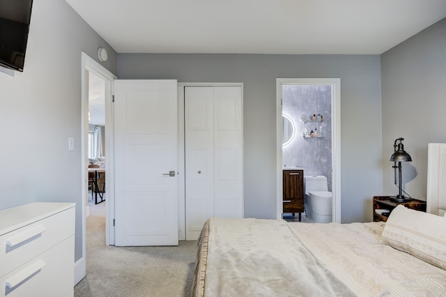 bedroom with light carpet, a closet, and ensuite bathroom