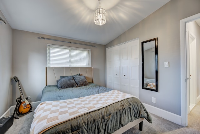 carpeted bedroom with baseboards, vaulted ceiling, and a closet