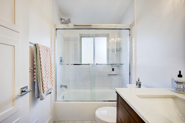 bathroom with enclosed tub / shower combo, vanity, and toilet