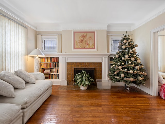 living area featuring hardwood / wood-style flooring, a fireplace, and ornamental molding