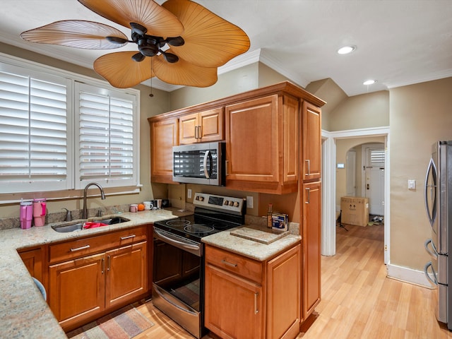 kitchen featuring crown molding, appliances with stainless steel finishes, sink, and light stone counters