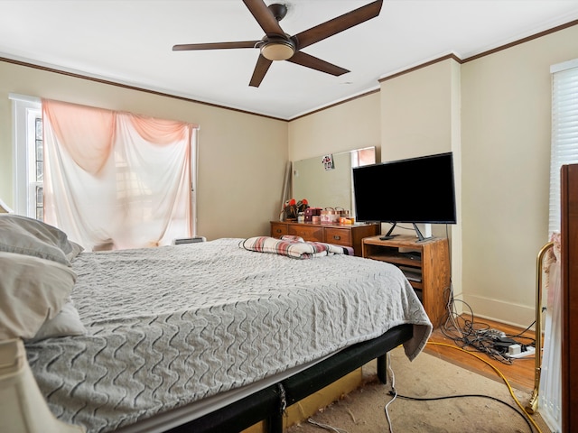 bedroom featuring crown molding, light hardwood / wood-style floors, and ceiling fan