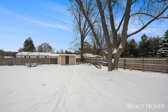 yard covered in snow with a storage shed