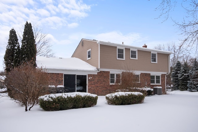 snow covered house with central air condition unit