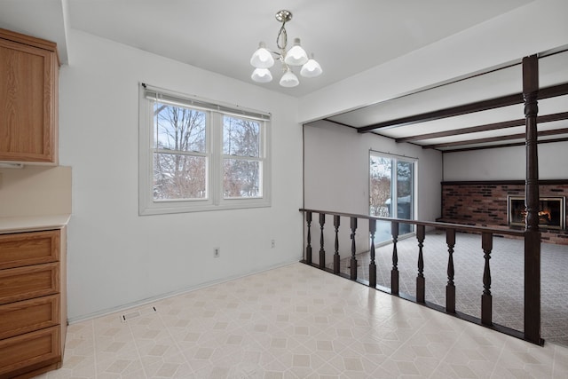 unfurnished room with a chandelier and beam ceiling