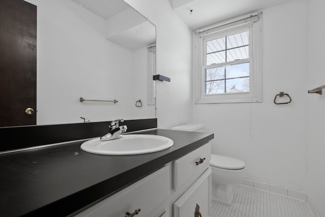 bathroom with toilet, vanity, and tile patterned flooring