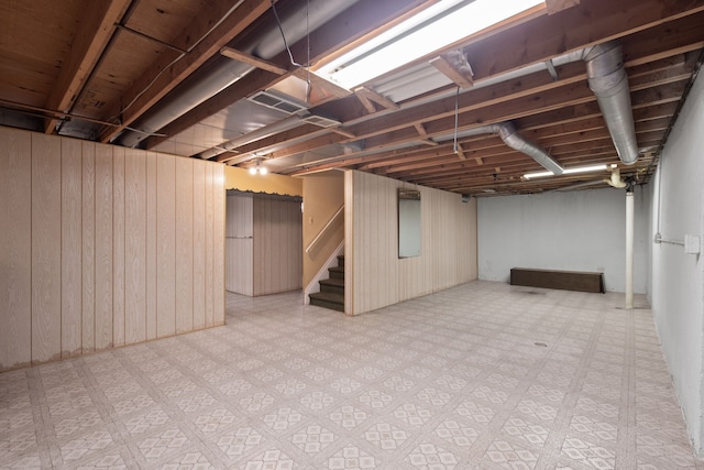 basement featuring wood walls