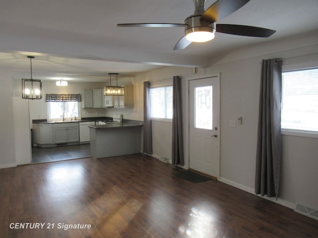 kitchen with white appliances, dark hardwood / wood-style floors, sink, and hanging light fixtures