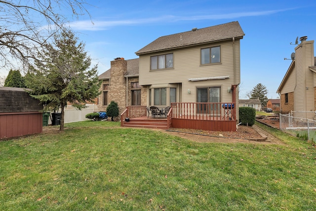 back of property with a wooden deck, a yard, and a storage unit