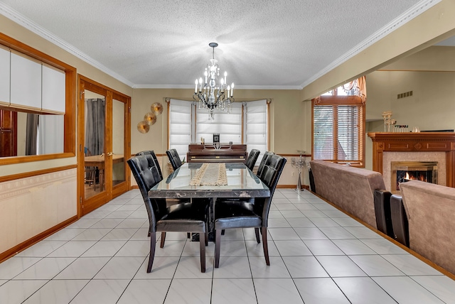 tiled dining room featuring ornamental molding, a textured ceiling, and a chandelier