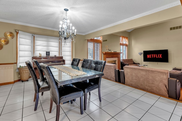 dining room with an inviting chandelier, light tile patterned floors, crown molding, and a textured ceiling