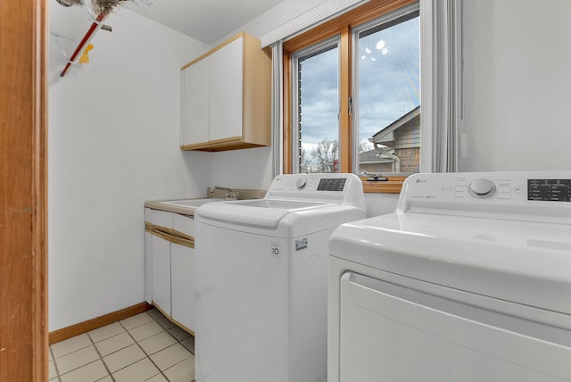 laundry area with light tile patterned flooring, cabinets, sink, and washing machine and dryer