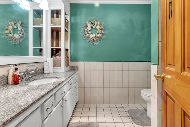 bathroom featuring tile walls, vanity, tile patterned floors, and toilet