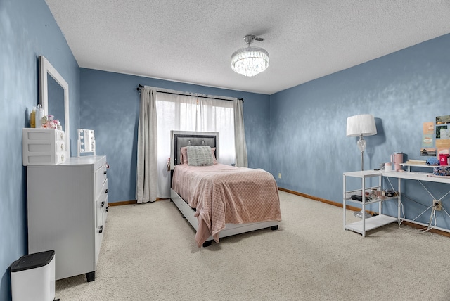 carpeted bedroom with a notable chandelier and a textured ceiling