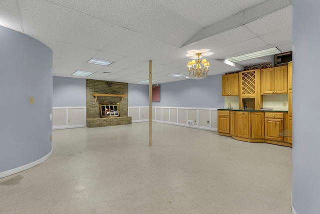 basement featuring a paneled ceiling and a fireplace