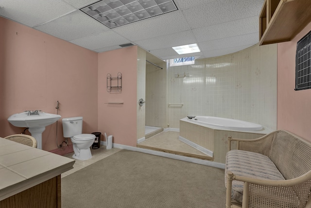 full bathroom featuring shower with separate bathtub, sink, tile patterned flooring, toilet, and a drop ceiling