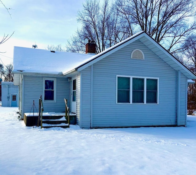 view of snow covered back of property