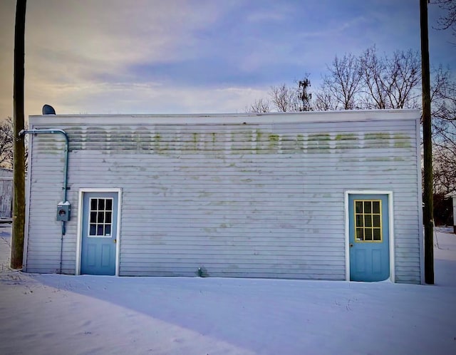 view of snow covered rear of property