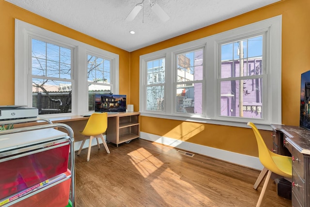 office featuring baseboards, built in desk, and wood finished floors