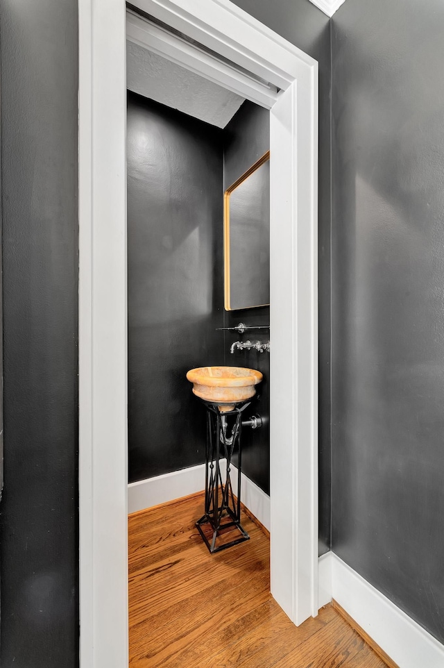 bathroom with baseboards, a sink, and wood finished floors