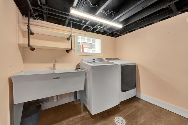 clothes washing area with laundry area, dark wood-style floors, separate washer and dryer, and baseboards