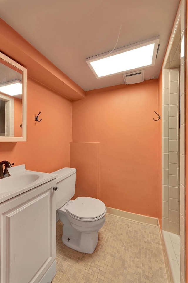 bathroom with vanity, visible vents, baseboards, toilet, and tile patterned flooring