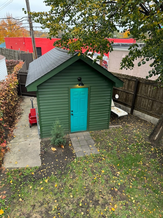 view of outbuilding featuring fence and an outbuilding