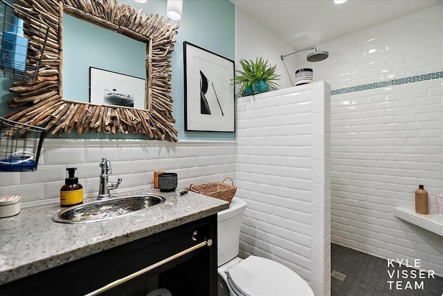 bathroom with tiled shower, toilet, tasteful backsplash, tile walls, and vanity