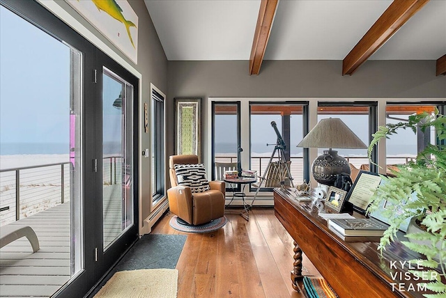 interior space featuring beam ceiling, baseboard heating, and a water view