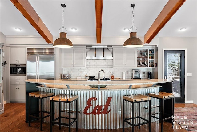 kitchen featuring pendant lighting, wall chimney exhaust hood, and a breakfast bar area