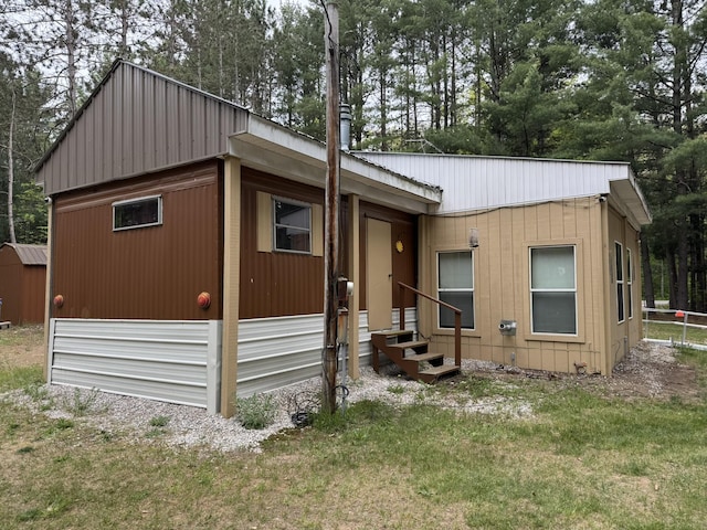 8210 N Johnson Rd, Irons, MI 49644 - view of front of home with metal roof, a front lawn, and entry steps